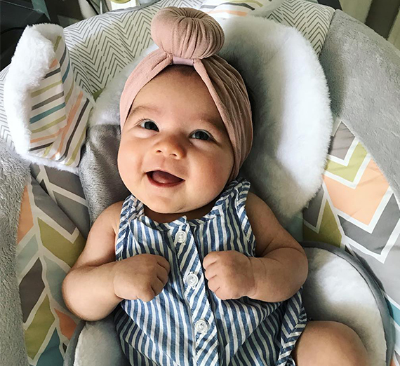 Man and woman holding a dog and a baby